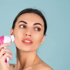 Kobieta używa różowej szczoteczki do twarzy. Czy szczoteczka medium to dobry wybór?