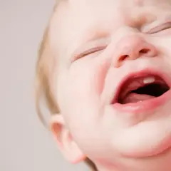 Maluch płacze, widać nowy ząbek. To pewnie gorączka przy ząbkowaniu.
