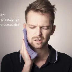 Mężczyzna z wyrazem bólu na twarzy przykłada fioletową ściereczkę do policzka, cierpiąc na ból szczęki.