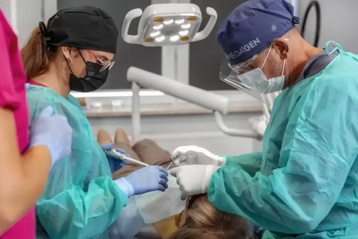 Stomatolodzy pracują przy pacjencie, zastanawiając się, ile rozpuszczają się szwy w jamie ustnej.