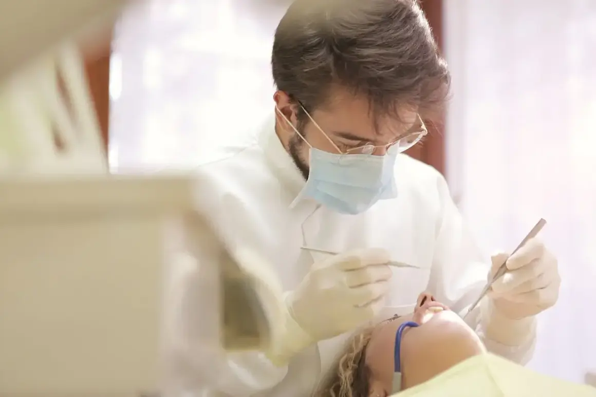 Dentysta w masce i rękawiczkach wykonuje zabieg. Pacjentka leży na fotelu. Pytanie: ile L4 po wyrwaniu ósemki?